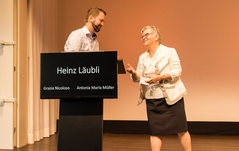 Frau übergibt einem Referenten ein Geschenk